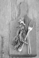 fork and knife with rosemary on a wooden board