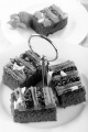 chocolate cake on a cake stand and plate with cake and strawberry in the background