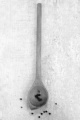 wooden spoon with some pepper corn on a white table