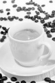 espresso in a small cup and coffee beans on a white table