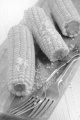 boiled corn cobs with coarse salt on a wooden board