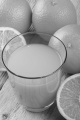 organic orange and freshly squeezed juice in a glass on rustic wood