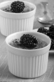 creme brulee with blackberries in a white bowl