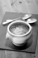 french onion soup in a bowl with spoon on slate