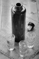 juniper brandy in small glasses and a dark bottle on jute