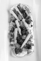 vegetarian tarte flambee with broccoli, sweet corn, tomato and lilac onions on a large white plate
