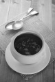 beetroot soup with chopped parsley in a white bowl on brown jute