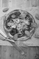 stone oven baked pizza with minced meat, tomato sauce, yellow, red chili and basil on paper