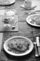 laid table with rustic home made potato pancakes, sugar in a bowl on slate, fresh pomegranate seed, lilac table runner, fork, knife, tea spoon and honey pot