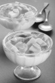 yogurt with mango cube and roasted almond sliver in a glass bowl