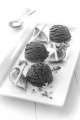 chocolate ice cream with fig, white chocolate sticks and chocolate curls on a white plate