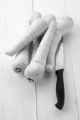 organic fresh parsnip with kitchen knife on wihte wood