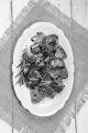 preparation of raw deer goulash with rosemary, peppercorn on an oval kitchen plate