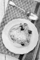 home made cherry crumble with powdered sugar on a white plate